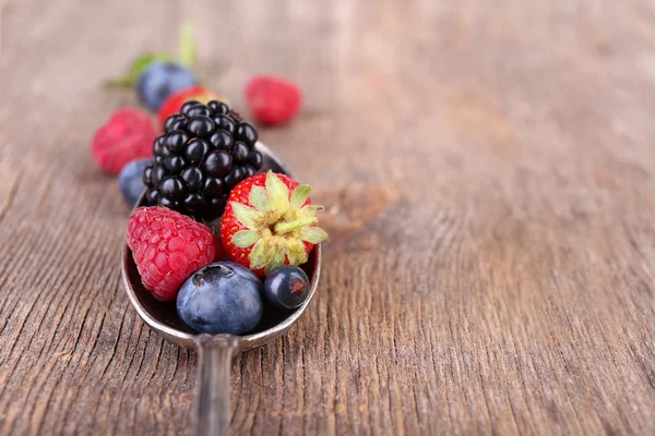 成熟甜的不同的莓果在老式的勺子，旧木制的桌子上 — 图库照片