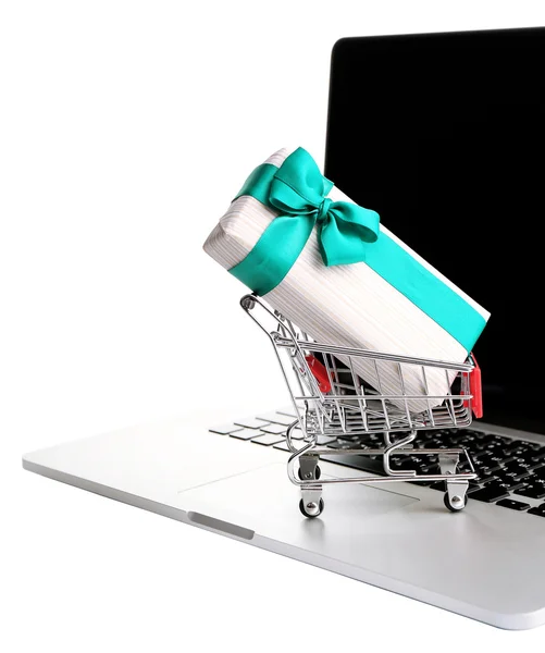 Carrito de compras en portátil con caja de regalo aislada en blanco —  Fotos de Stock