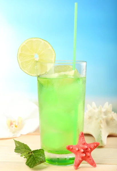 Coquetel refrescante na mesa de madeira no fundo azul — Fotografia de Stock