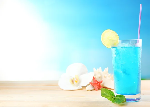 Erfrischender Cocktail auf Holztisch auf blauem Hintergrund — Stockfoto