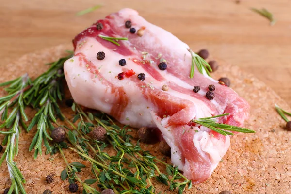 Pancetta cruda con spezie sul tavolo di legno — Foto Stock