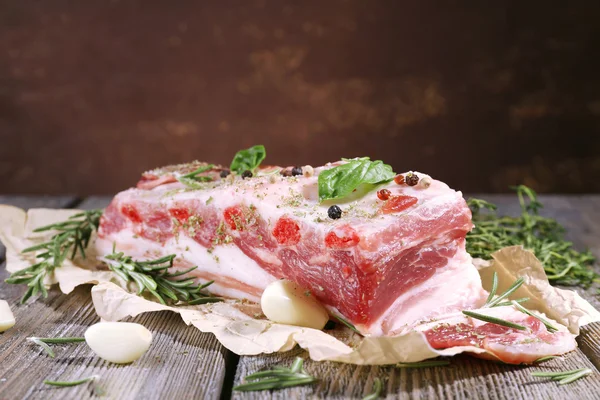 Raw bacon with spices on wooden table — Stock Photo, Image