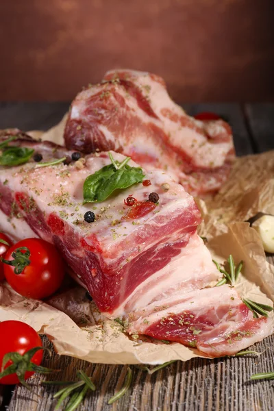 Bacon cru com especiarias e tomates na mesa de madeira — Fotografia de Stock