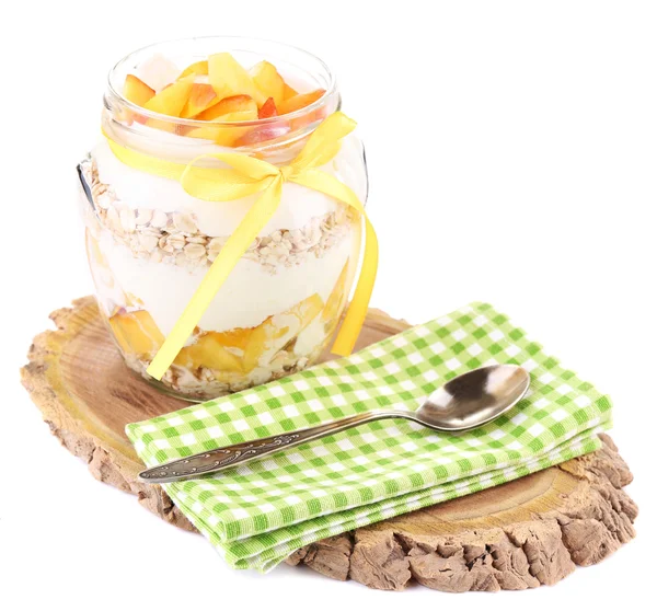 Petit déjeuner sain - yaourt aux pêches fraîches et muesli servi dans un bocal en verre sur un plateau en bois, isolé sur du blanc — Photo