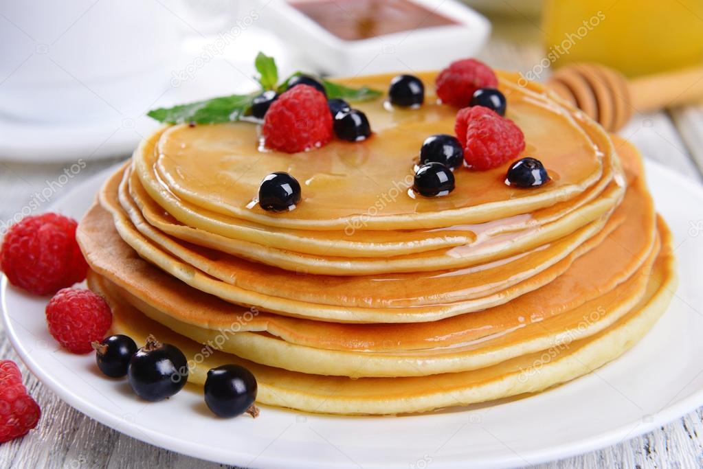 Sweet pancakes with berries on table close-up