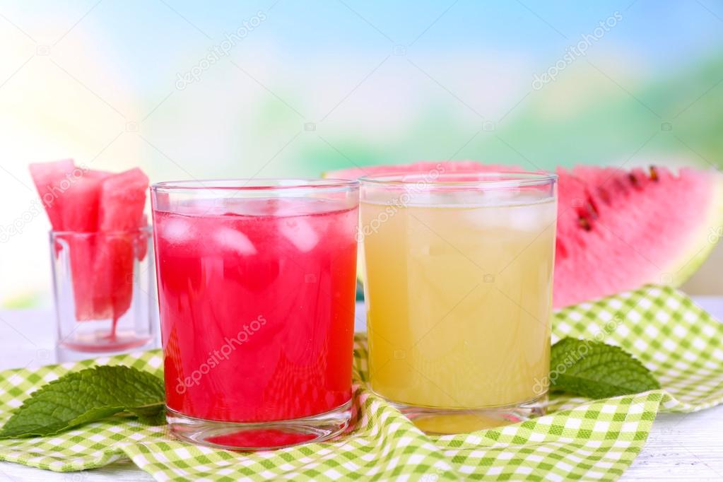 Watermelon cocktail and melon smoothie on wooden table on natural background