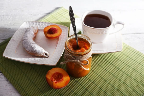 Café da manhã leve com xícara de chá e geléia caseira na mesa de madeira — Fotografia de Stock