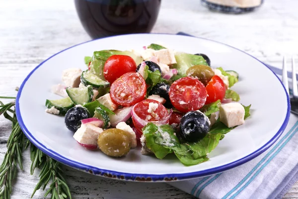 Piatto di insalata greca servito con vino su tovagliolo su tavolo di legno su sfondo scuro — Foto Stock