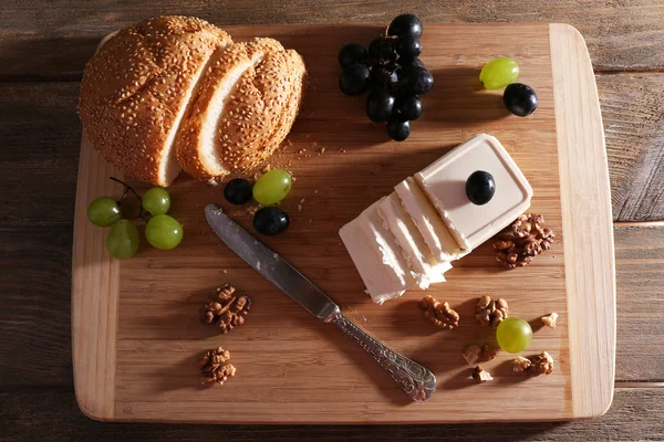 still life with tasty cheese, grape and bread, close up