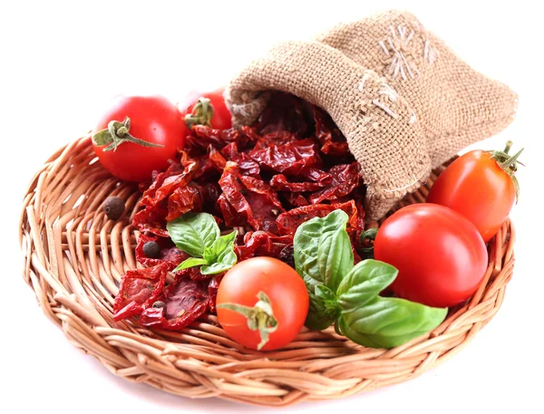 Sun dried tomatoes, fresh tomatoes on wicker mat,  basil leaves, isolated on white — Stock Photo, Image