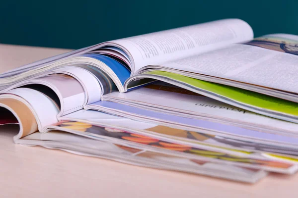 Revistas em mesa de madeira no fundo escuro — Fotografia de Stock