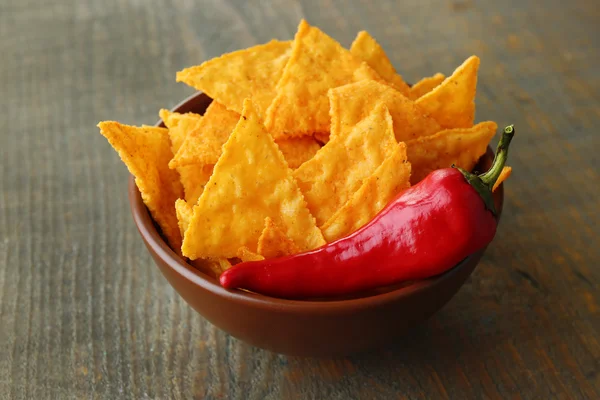 Nachos saborosos em tigela de cor no fundo de madeira — Fotografia de Stock