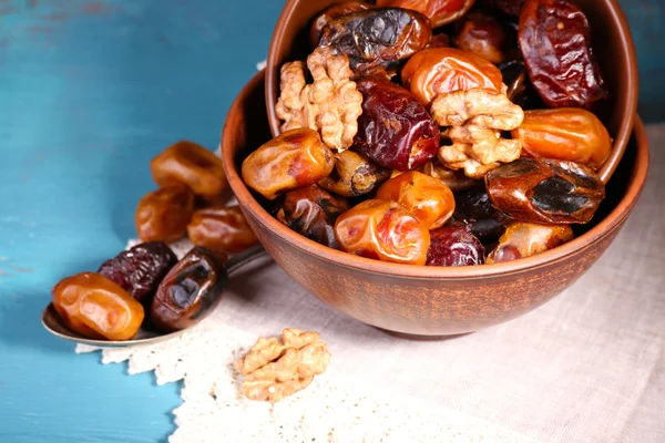 Tasty dates fruits in bowls, on blue wooden background — Stock Photo, Image