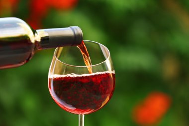 Şarap kadehine dökülen kırmızı şarap, yakın plan.