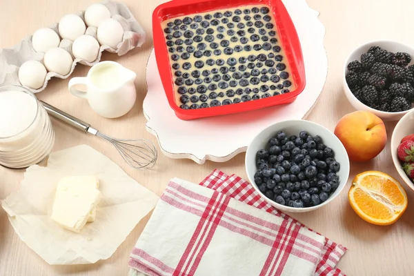 Baking tasty pie and ingredients for it on table in kitchen — Stock Photo, Image