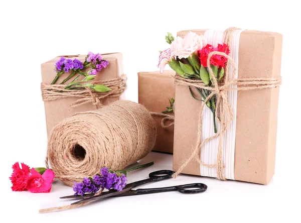 Hermosos regalos con flores y cuerda decorativa, aislados en blanco —  Fotos de Stock