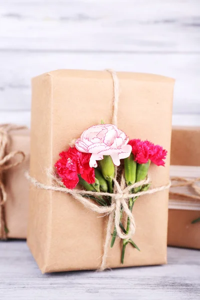 Hermosos regalos con flores, sobre fondo de madera viejo — Foto de Stock