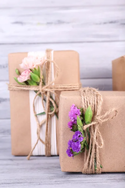 Beautiful gifts with flowers, on old wooden background — Stock Photo, Image