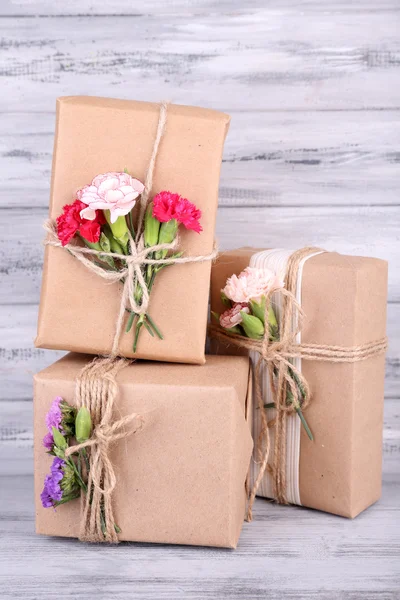 Hermosos regalos con flores, sobre fondo de madera viejo —  Fotos de Stock