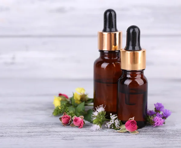 Esenciální olej s různými medicína rostliny, na dřevěné pozadí — Stock fotografie