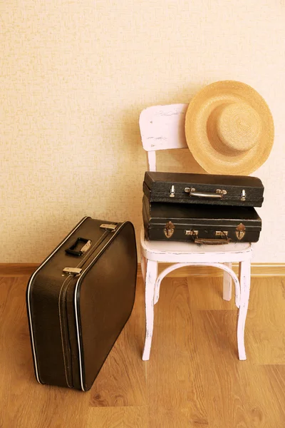 Vinobraní starých cestovních kufrů na podlaze a židle s ženské věci — Stock fotografie