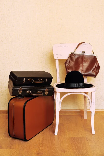 Vintage régi utazási bőröndök, a padló és a női dolgok szék — Stock Fotó