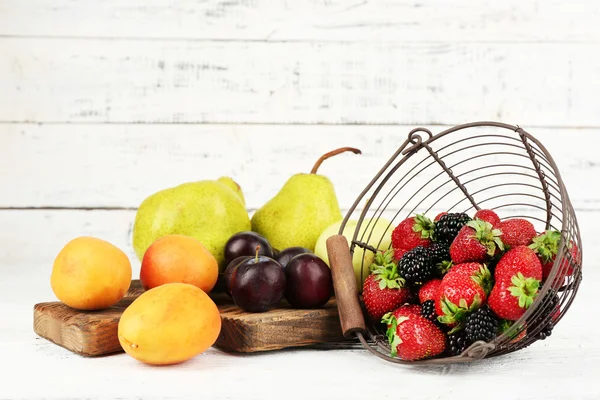 Frutas maduras y bayas sobre mesa sobre fondo de madera — Foto de Stock