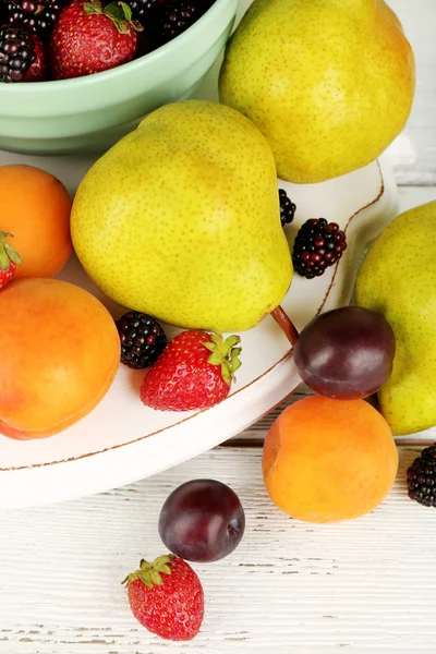 Rijp fruit en bessen in kom op tafel close-up — Stockfoto