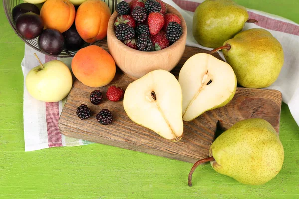 Frutas maduras e bagas na tigela na mesa de perto — Fotografia de Stock