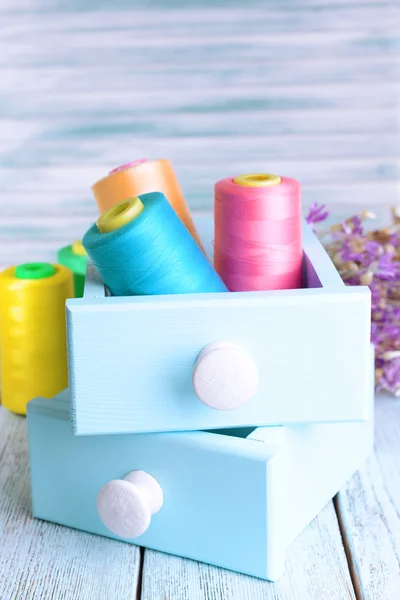 Sewing Accessories in wooden boxes on table on light blue background — Stock Photo, Image