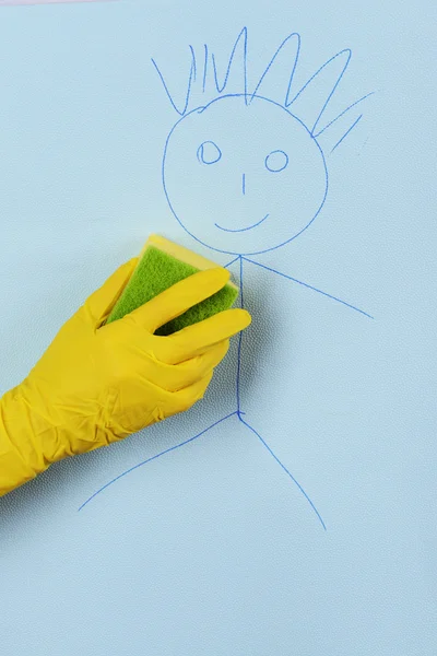Рука об руку вытирает детям рисунки на обоях — стоковое фото