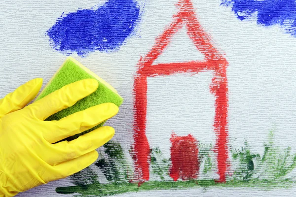 Main dans le gant essuyant les enfants dessin sur papier peint — Photo