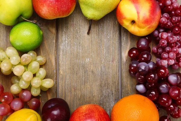 Sortiment av saftiga frukter på trä bakgrund — Stockfoto