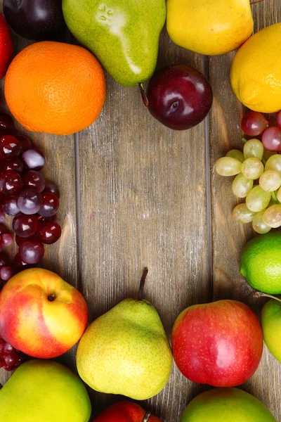 Assortment of juicy fruits on wooden background — Stock Photo, Image