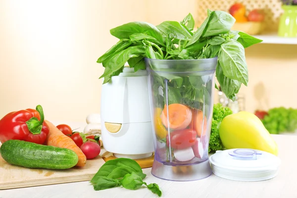 Licuadora con verduras frescas en la mesa de la cocina — Foto de Stock