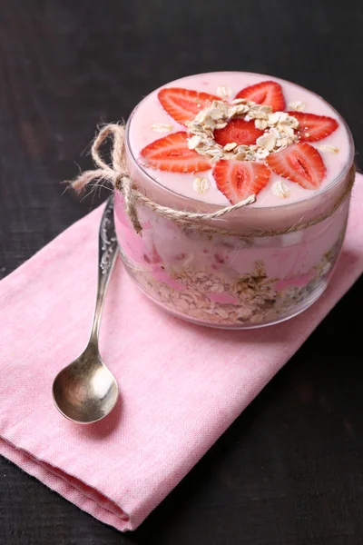 Colazione sana - yogurt con fragole e muesli servito in barattolo di vetro, su sfondo di legno — Foto Stock