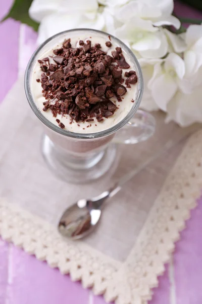 Yogurt, with chocolate cream, chopped chocolate and muesli served in glass on color  wooden background — Stock Photo, Image