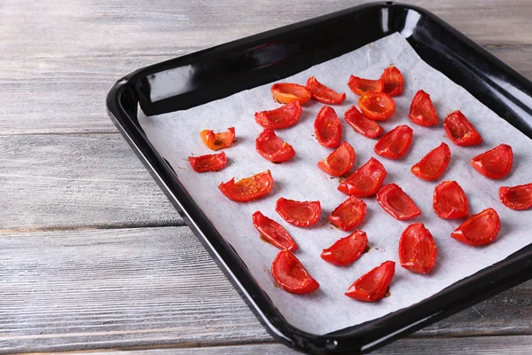 Sun dried tomatoes on drying tray, on wooden background — Stock Photo, Image