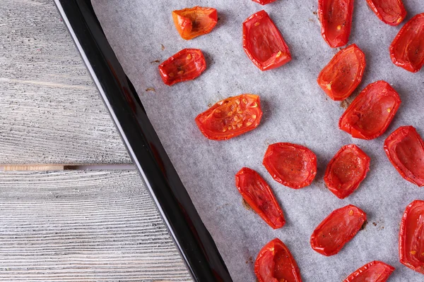Sun dried tomatoes on drying tray, on wooden background — Stock Photo, Image