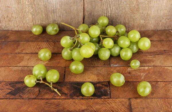Groene druif op houten tafel op houten achtergrond — Stockfoto