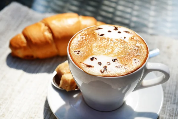 Tasse Kaffee mit niedlicher Zeichnung auf dem Tisch, Nahaufnahme — Stockfoto