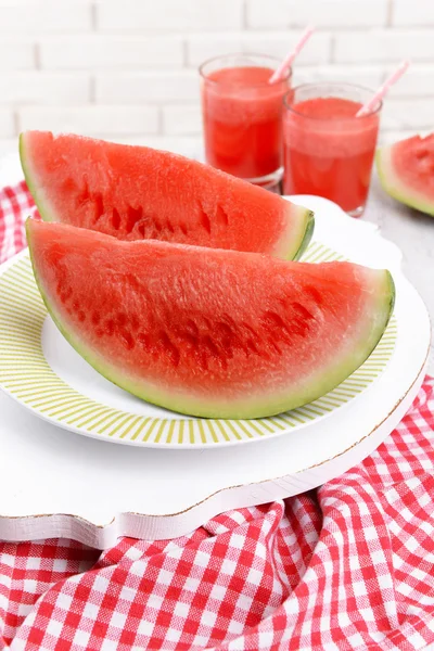 Saftige Wassermelone auf dem Tisch auf Backsteinmauer Hintergrund — Stockfoto