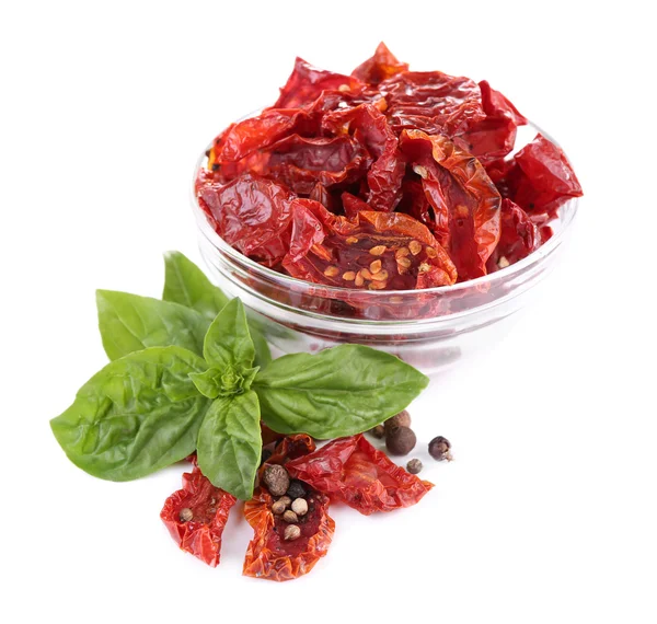 Pomodori secchi in ciotola di vetro e foglie di basilico, isolati su bianco — Foto Stock