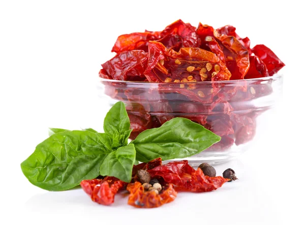 Pomodori secchi in ciotola di vetro e foglie di basilico, isolati su bianco — Foto Stock