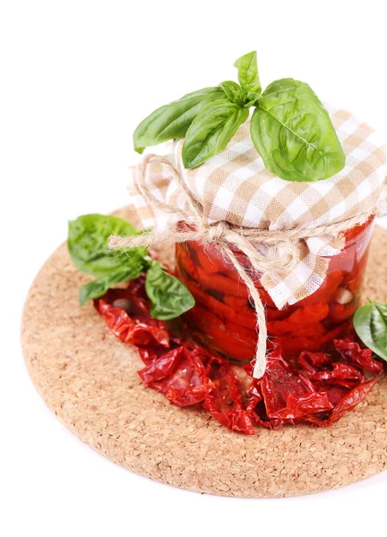 Sun dried tomatoes in glass jar and basil leaves isolated on white — Stock Photo, Image