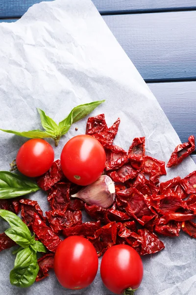 Sun dried and fresh tomatoes, basil leaves, garlic on color wooden background — Stock Photo, Image