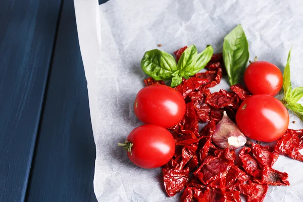 Sun dried and fresh tomatoes, basil leaves, garlic on color wooden background — Stock Photo, Image