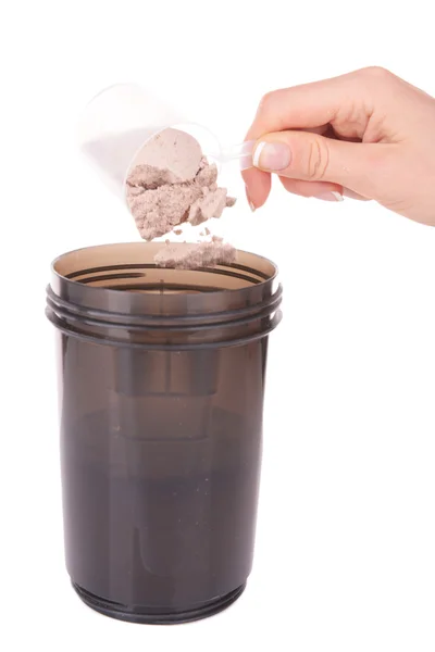 Female hand holding scoop with whey protein powder and plastic shaker isolated on white — Stock Photo, Image