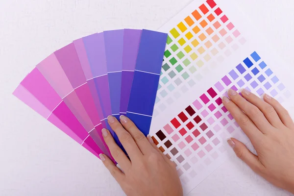 Woman choosing color for wall from swatches in room — Stock Photo, Image