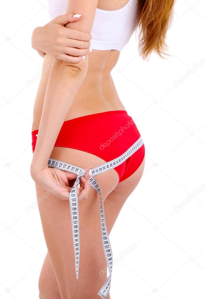 Young woman with orange and measuring tape isolated on white